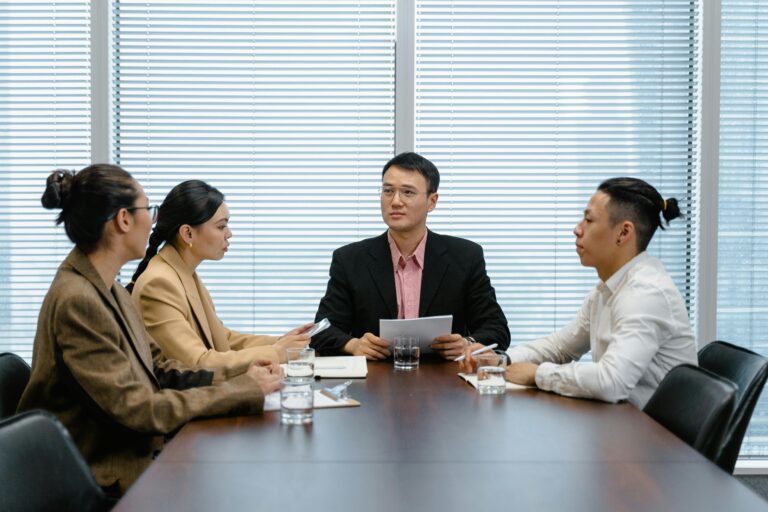 Business professionals engaged in a focused team meeting discussing strategies in an office setting.